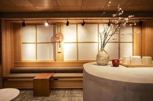 Miru Kyoto Gion في كيوتو: غرفة مع طاولة و مزهرية مع الزهور فيها