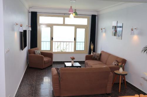 a living room with two couches and a window at Nour 1 in Alexandria
