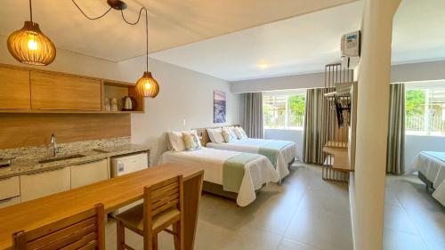 a hotel room with a bed and a kitchen at Costa Solar Lagoa in Florianópolis