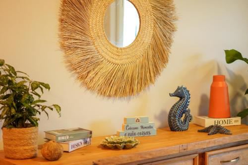 a table with a mirror and a shelf with books at Costa Solar Lagoa in Florianópolis