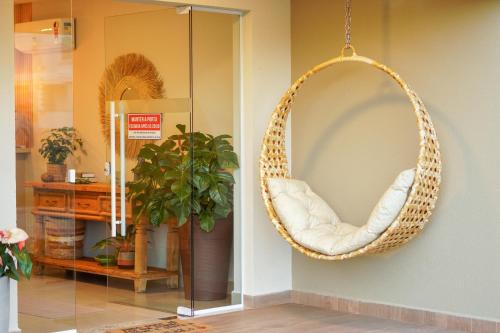 a wicker rattan chair hanging on a wall at Costa Solar Lagoa in Florianópolis