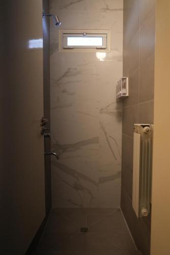 a bathroom with a shower with a glass door at Motel A.C.A. Cipolletti in Cipolletti