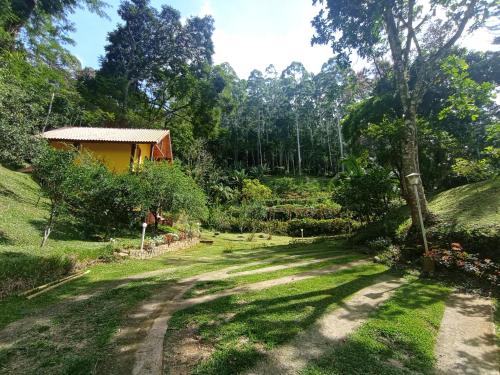 um caminho que leva a uma casa num jardim em Sitio Recanto da Paz Chalés - casa e chalé para temporada em São Pedro da Serra