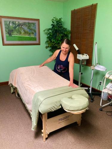 a woman standing next to a bed in a room at Front Street Inn and Spa in Morro Bay
