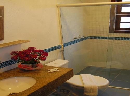 a bathroom with a toilet and a sink and a shower at Pousada Jataí in Cabo Frio
