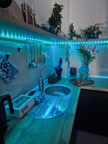 um balcão de casa de banho com um lavatório e luzes azuis em Kathisma Trebinje em Trebinje