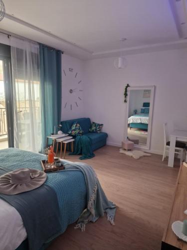 um quarto com uma cama azul e um sofá em Kathisma Trebinje em Trebinje