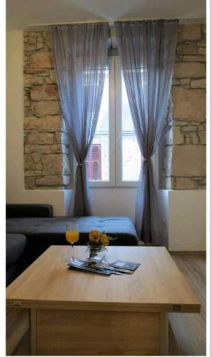 a living room with a table and a window at Colloseum View from the apartment in Pula