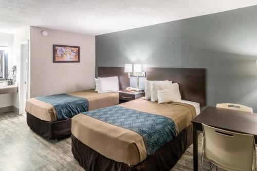 a hotel room with two beds and a table at Econo Lodge in Crestview