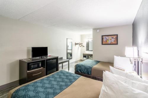 a hotel room with two beds and a flat screen tv at Econo Lodge in Crestview
