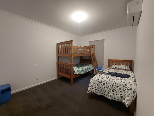 a bedroom with two beds and a bunk bed at bamboo in Apollo Bay