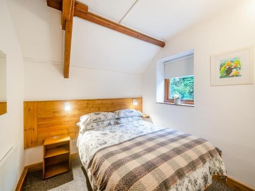 1 dormitorio con cama y ventana en Hayloft - E3759, en Berrynarbor