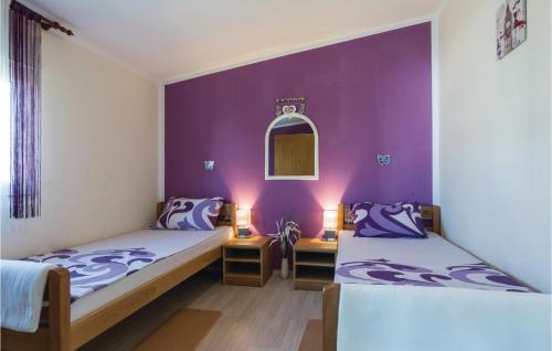 two beds in a room with purple walls at Amazing Apartment In Vir With 2 Bedrooms And Wifi in Vir