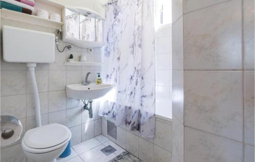 a white bathroom with a toilet and a sink at Amazing Apartment In Vir With 2 Bedrooms And Wifi in Vir