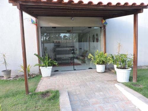 a pavilion with potted plants on a patio at Pousada Porto Sol in Porto De Galinhas