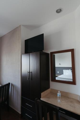 a dining room with a table and a mirror at Hoteles Unico Express in León