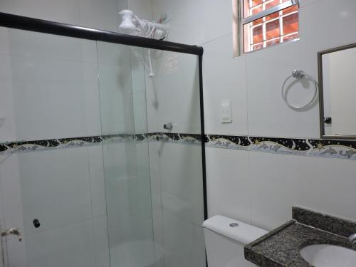 嘎林海斯港Pousada Porto Sol的带玻璃淋浴和水槽的浴室