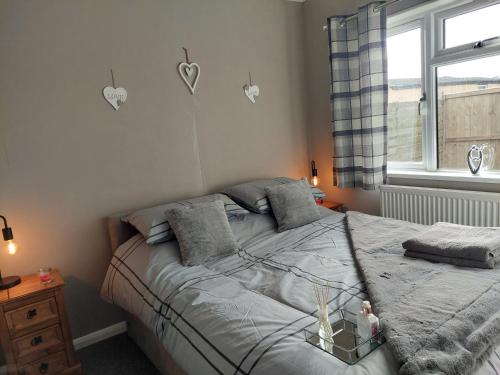 a bedroom with a bed and a window with hearts on the wall at Love Nest in Deal