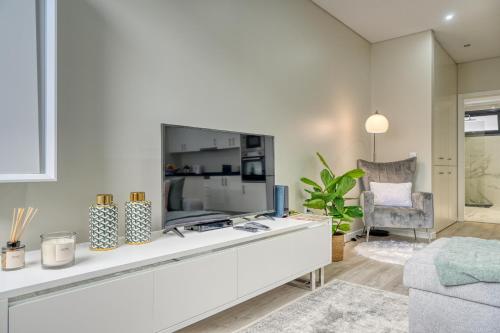 a living room with a large tv and a chair at Tristão Vaz I, a Home in Madeira in Machico