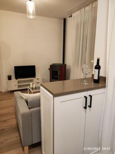a living room with a couch and a bottle of wine at Casa Dina in Carballino