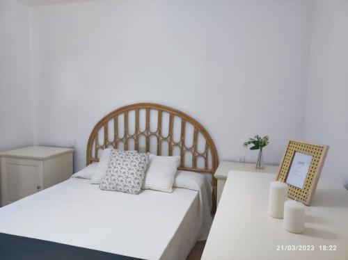 a bedroom with a white bed and a table at Casa Dina in Carballino