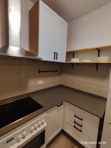 a kitchen with white cabinets and a stove top oven at Casa Dina in Carballino