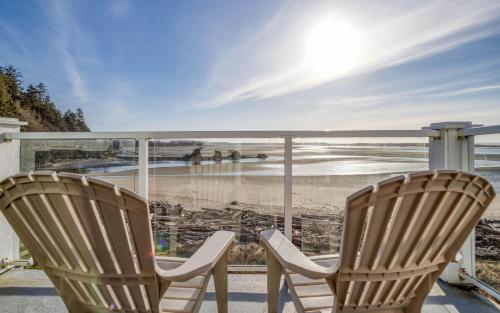 two chairs sitting on a balcony looking at the beach at Waters Edge 407 in Lincoln City
