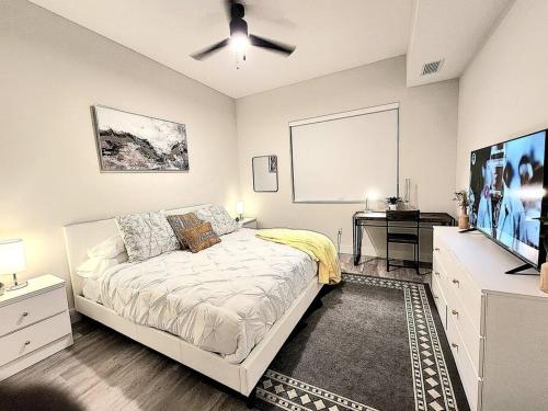 a bedroom with a bed and a flat screen tv at Luxe & cozy 3Beds,2rooms,EV Gym Near Beaches&Downtown WPB in West Palm Beach