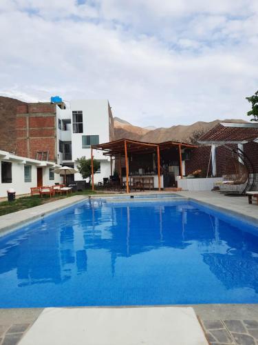 a large blue swimming pool next to a building at HOTEL MAR Y LAGO in Lunahuaná