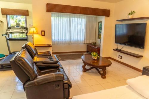 un soggiorno con mobili in pelle e una TV a schermo piatto di Magnifica Villa Palmeras luxurious 4 Br 6 Bds 4 Ba private pool lagoon front super fast Wifi a Cancún