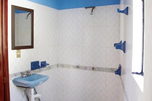 uma casa de banho com um lavatório azul e um espelho. em Casa Santiago em Oaxaca City