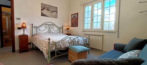 een slaapkamer met een bed en een bank bij Lovely Beach House For Two in Torre del Lago Puccini
