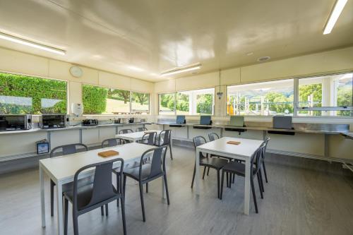 a classroom with tables and chairs in a cafeteria at Akaroa Top 10 Holiday Park in Akaroa
