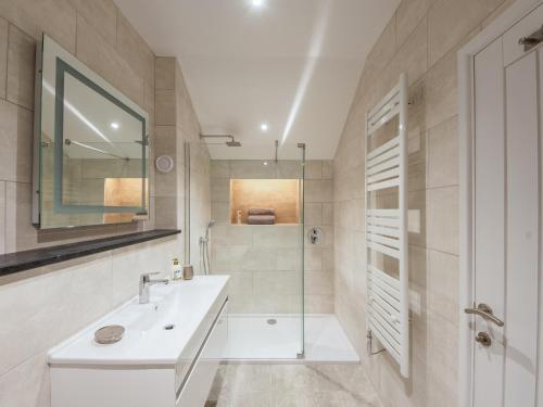 a white bathroom with a shower and a sink at Fir Cottage - Uk38485 in Saltash