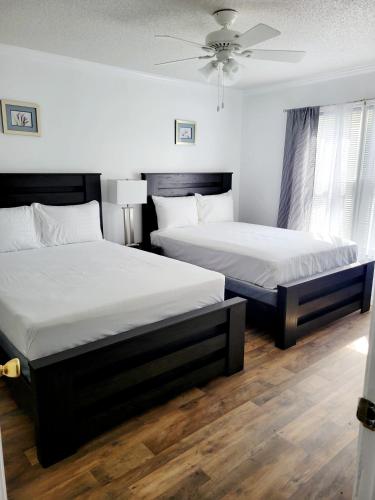 sypialnia z 2 łóżkami i wentylatorem sufitowym w obiekcie Convenient and Comfortable w mieście Macon