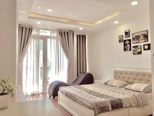 - une chambre avec un lit et une grande fenêtre dans l'établissement Tropical House, à Hô-Chi-Minh-Ville