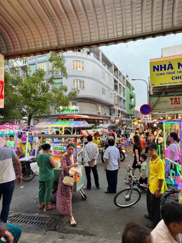 a group of people standing around in a street market at nhà nghỉ thanh thuy 2 in Ha Tien