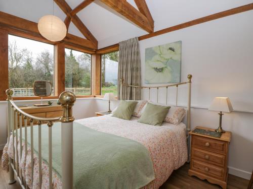 een slaapkamer met een bed en een raam bij Oxbarton in Butcombe
