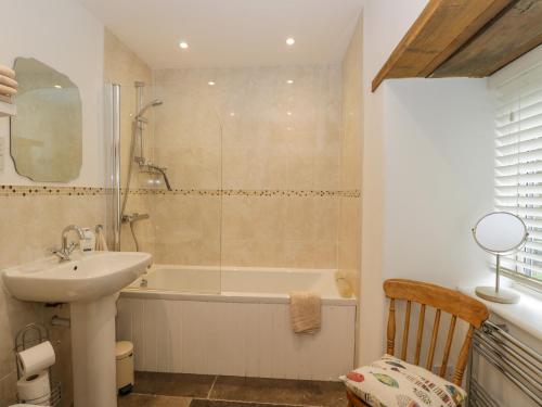 a bathroom with a sink and a bath tub and a sink at Oxbarton in Butcombe