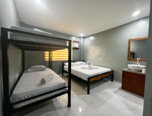 een slaapkamer met 2 stapelbedden en een wastafel bij Monati Hostel Panglao in Panglao