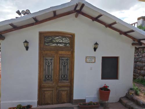 a house with a wooden door and a television at Palacio Manco Capac by Ananay Hotels in Cusco