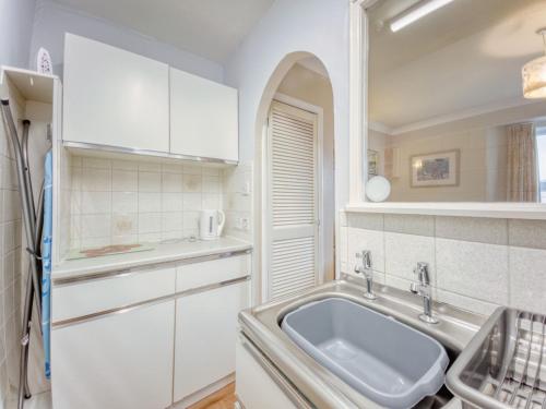 uma cozinha com armários brancos e um lavatório em Apartment 6 - 1 Bedroom Town view em Paignton