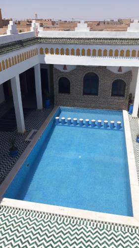 a large swimming pool in front of a building at Casa Laman in Merzouga