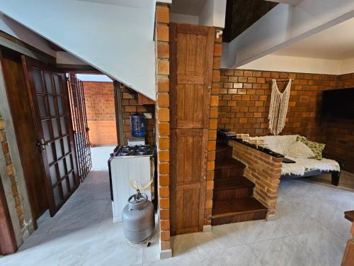 um quarto com uma parede de tijolos e uma cozinha com um fogão em Lindo chalé completo para até 10 pessoas com piscina aquecida em Gravatá