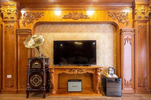 a living room with a fireplace and a tv at Glenda Tower Moc Chau Hotel in Mộc Châu