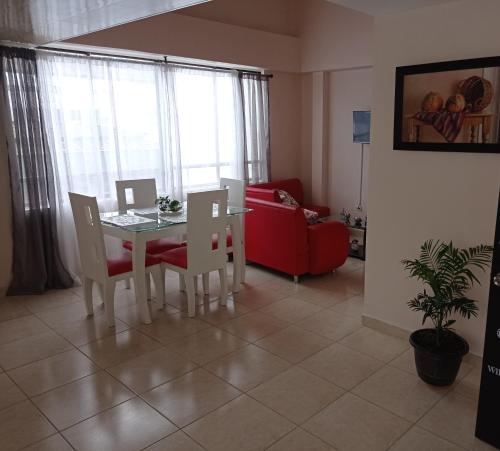 sala de estar con mesa, sillas y sofá rojo en Apartamento ideal si buscas ubicación y espacio, en Pereira