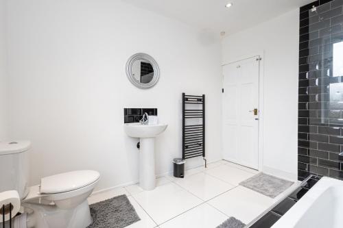 a bathroom with a toilet and a sink and a shower at Cheadle village in Cheadle