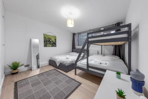 a bedroom with two bunk beds and a table at Sleep14 in Victoria London 43VPR in London
