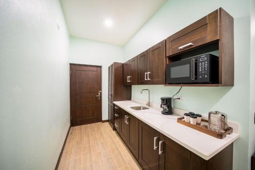 a kitchen with wooden cabinets and a microwave at Bungalows Punta Uva in Punta Uva