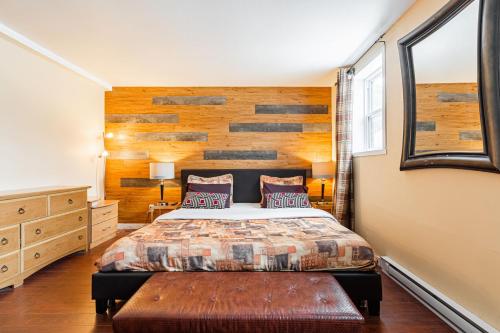 - une chambre avec un lit et un mur en bois dans l'établissement Chez Joe - CITQ #3I74I4, à Terrebonne